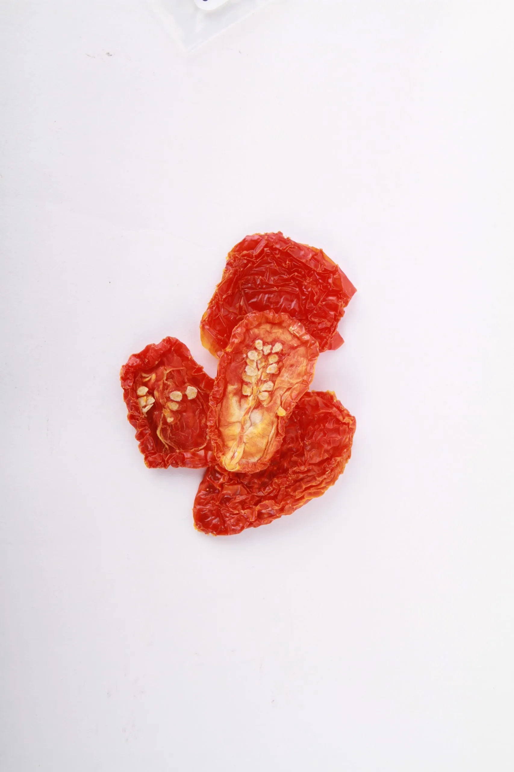 Traina® California Sun Dried Tomatoes,, halves - small pile of sun dried tomatoes on white background.