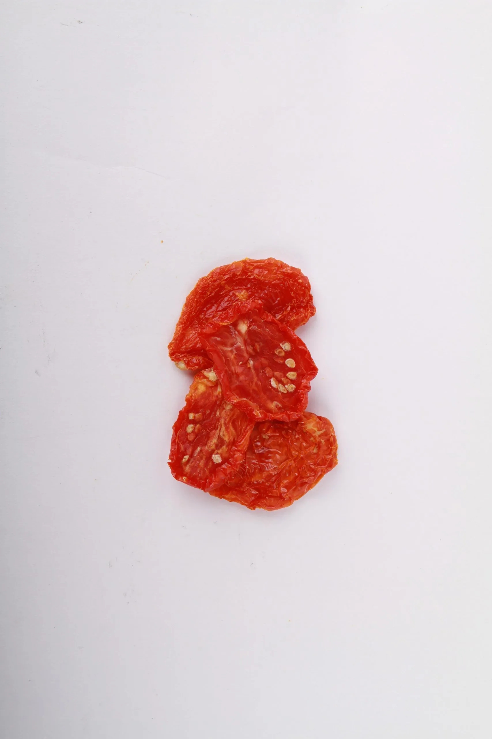 Traina® Mediterranean sun dried tomato, halves – small pile of sun-dried tomatoes on white background.