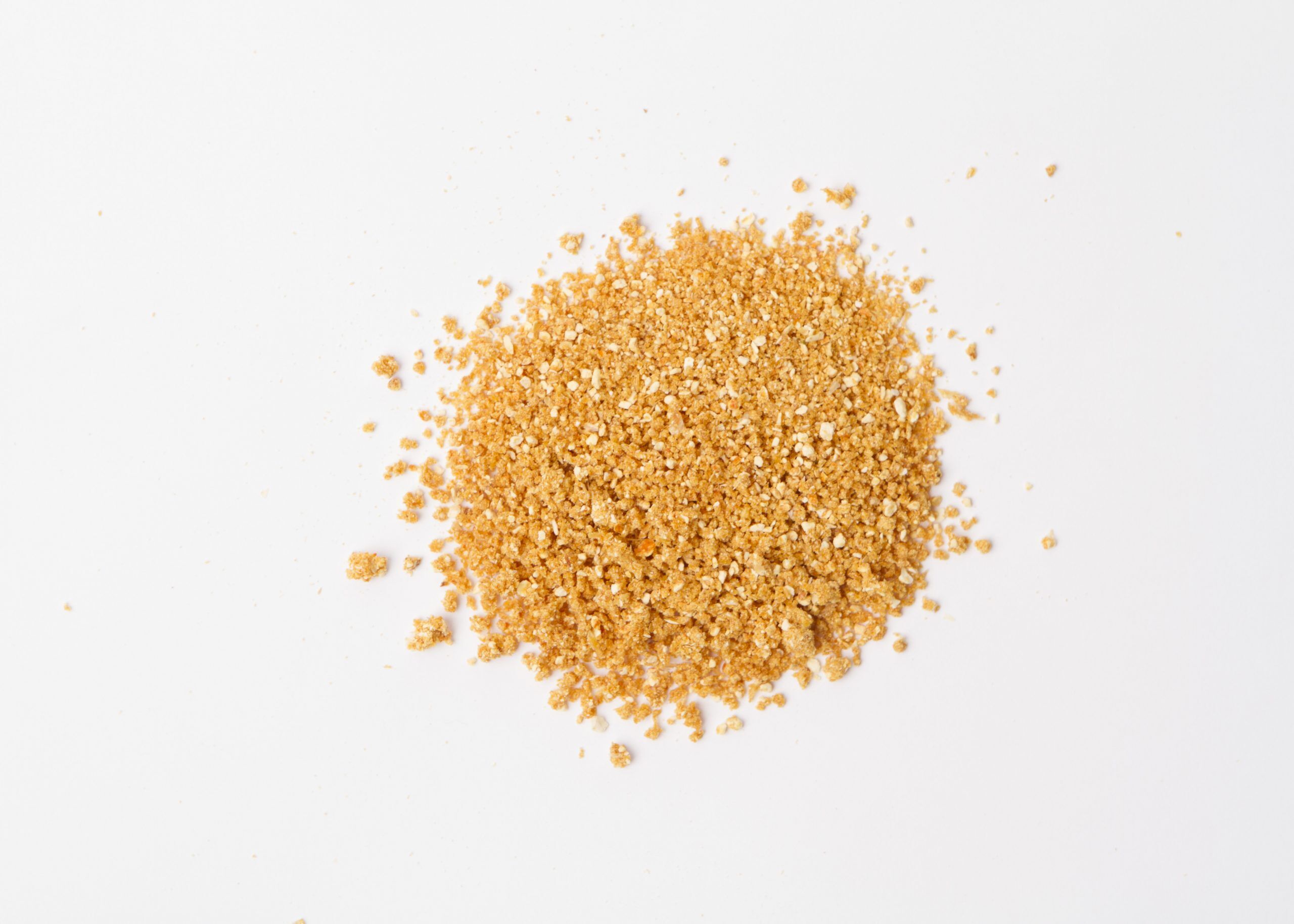 Traina® Natural Dried Orange, granules - small pile of dehydrated fruit on white background
