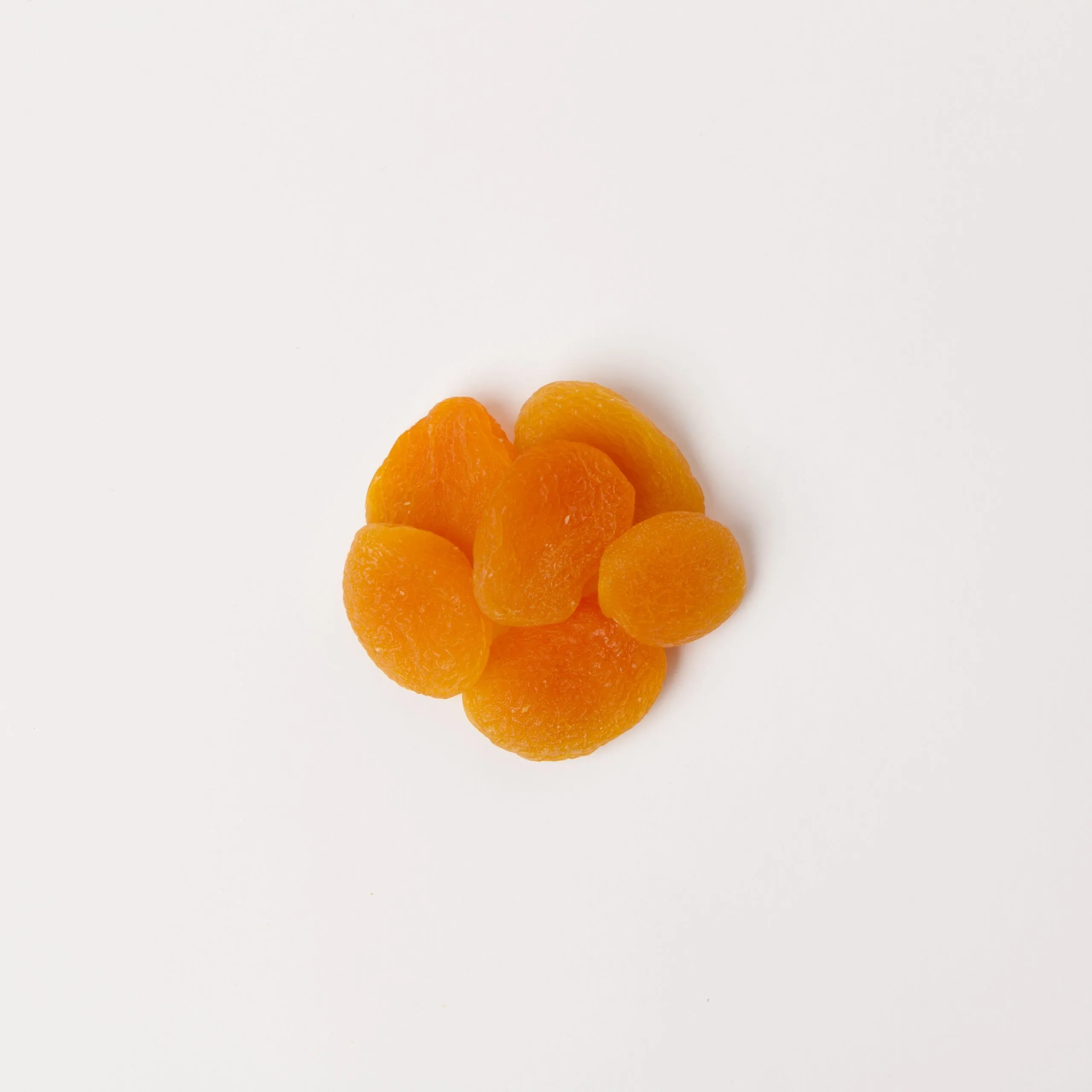 Turkish Apricots, pitted, halves, #4 - small pile of sun dried fruit on white background.