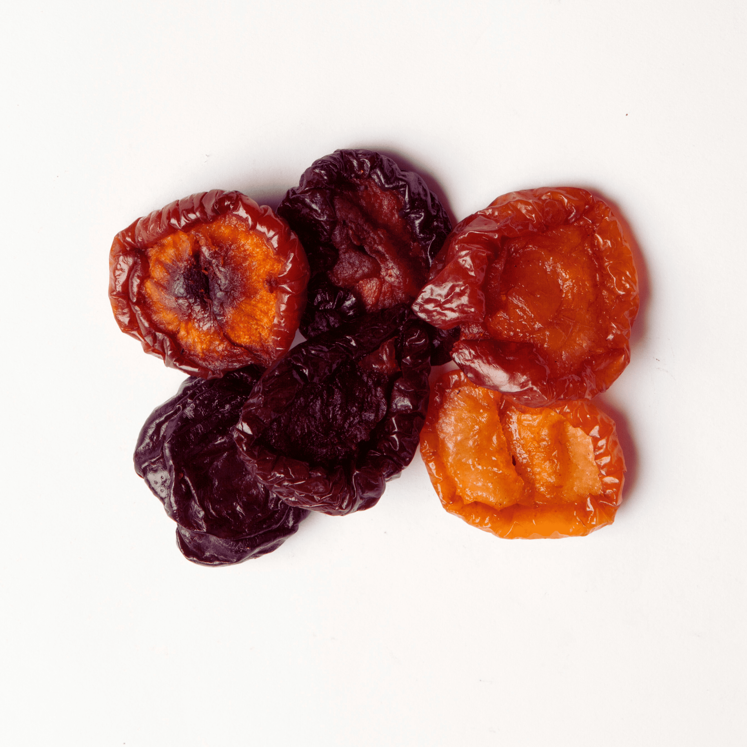 Traina® California Sun Dried Angelino Plums, Varigrade, halves - small pile of sun dried fruit on white background.