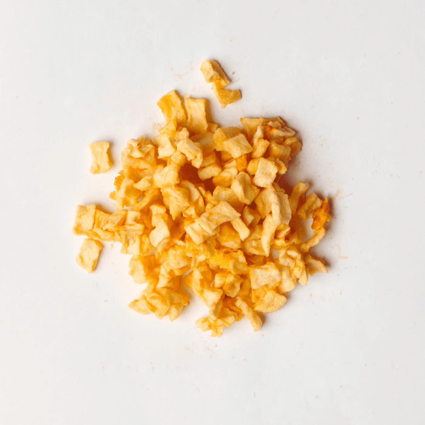 Traina® Natural Dried Apples, diced- small pile of sun dried fruit on white background.