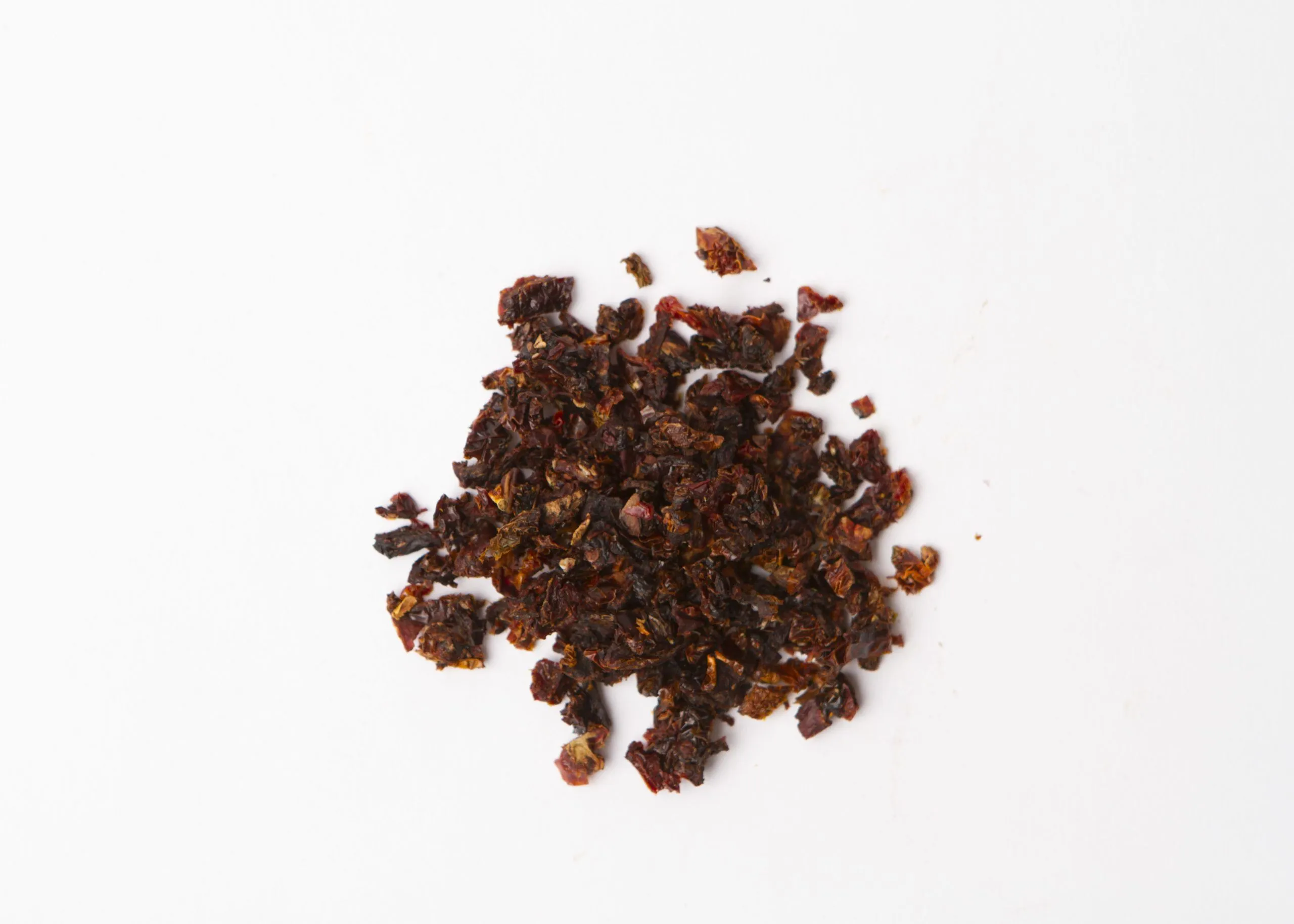 Traina® Organic California Sun Dried Tomatoes, double-diced - small pile of sun dried tomatoes on white background.