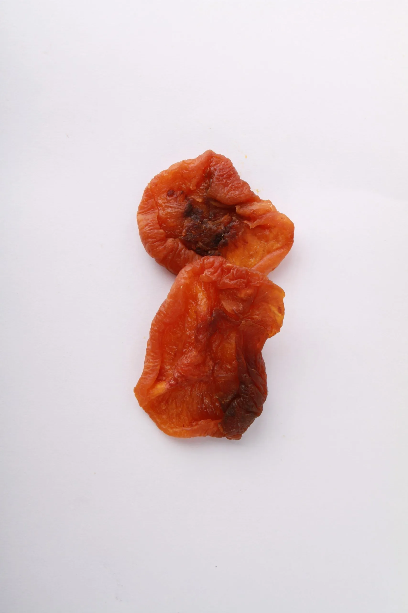 Traina® Dried Peaches, Varigrade halves- small pile of sun dried fruit on white background.