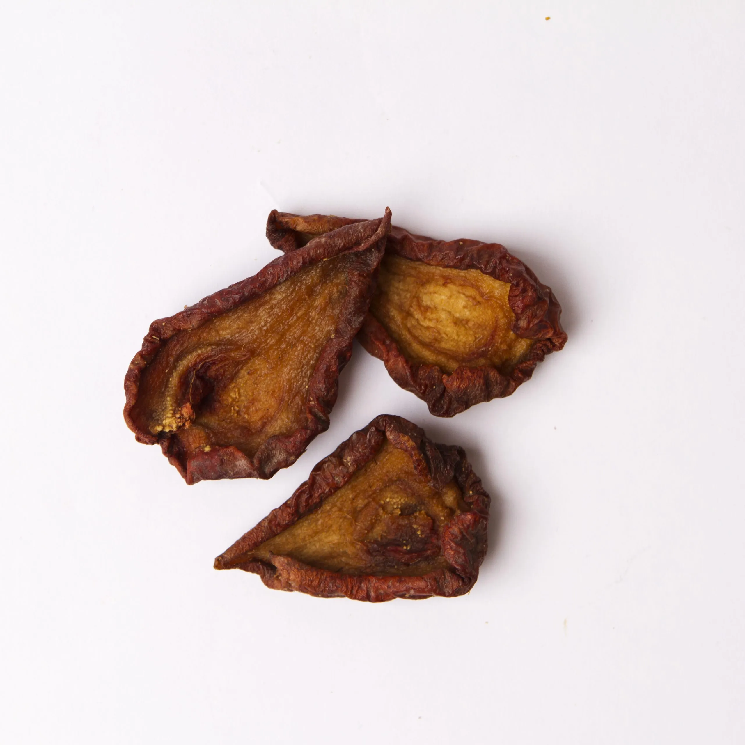 Traina® Organic Dried Pears, halves - small pile of sun dried fruit on white background.