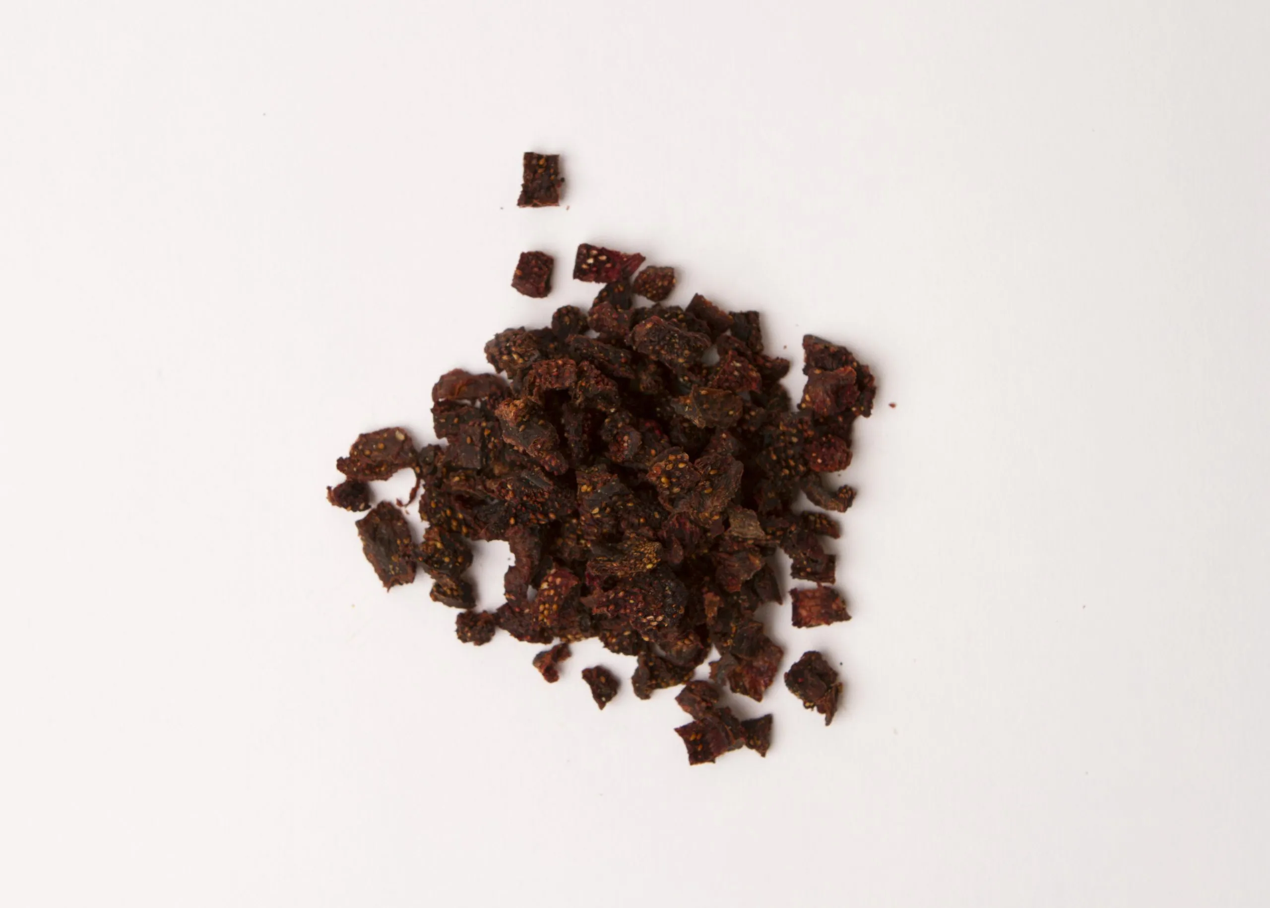 Traina® Natural Dried Strawberries, No Added Sugar, diced - small pile of sun dried fruit on white background.