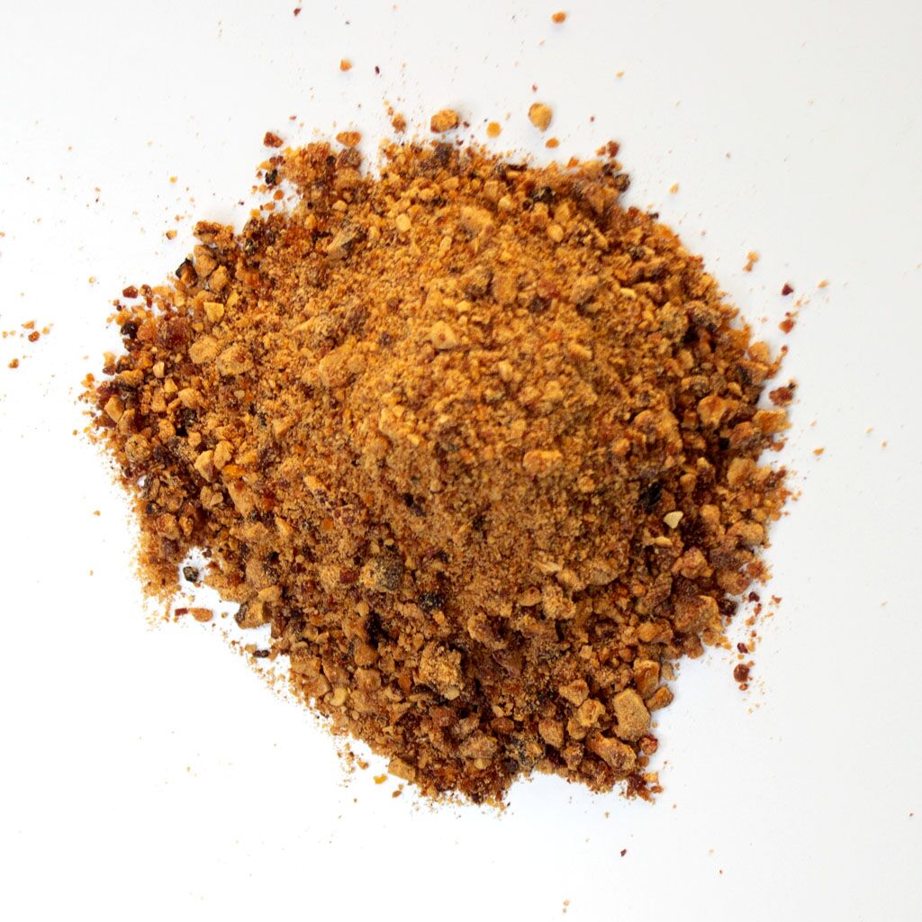 Traina® Natural California Sun Dried Peaches, granules - small pile of sun dried fruit on white background.