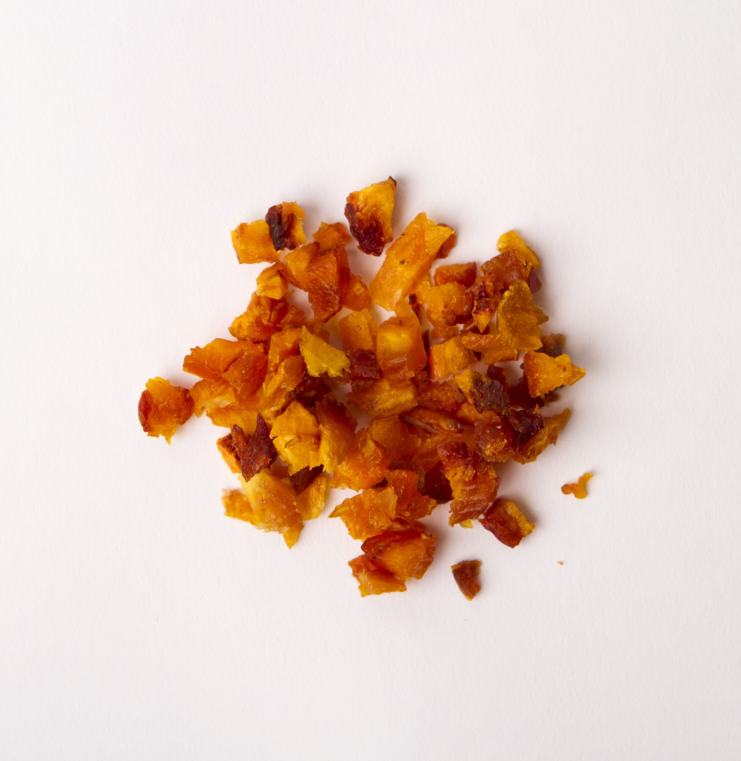 Traina® California Sun Dried Nectarines, double-diced - small pile of sun dried fruit on white background.