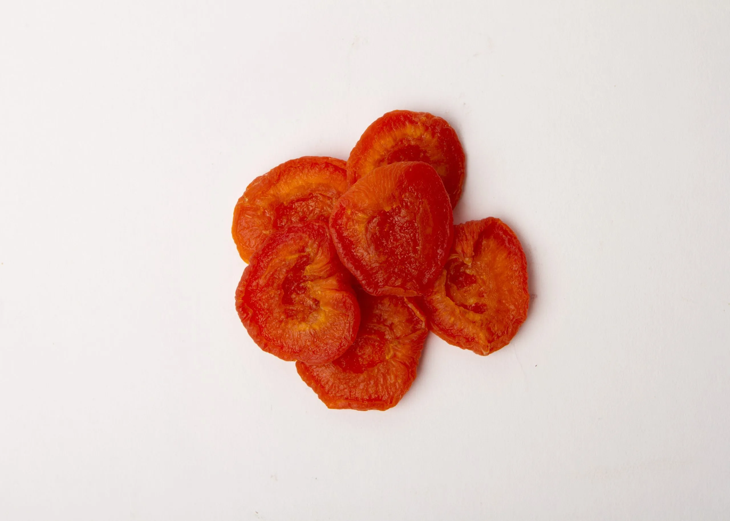 Traina® California Sun Dried Ruby Royal Apricots, Extra Fancy, halves - small pile of sun dried fruit on white background.