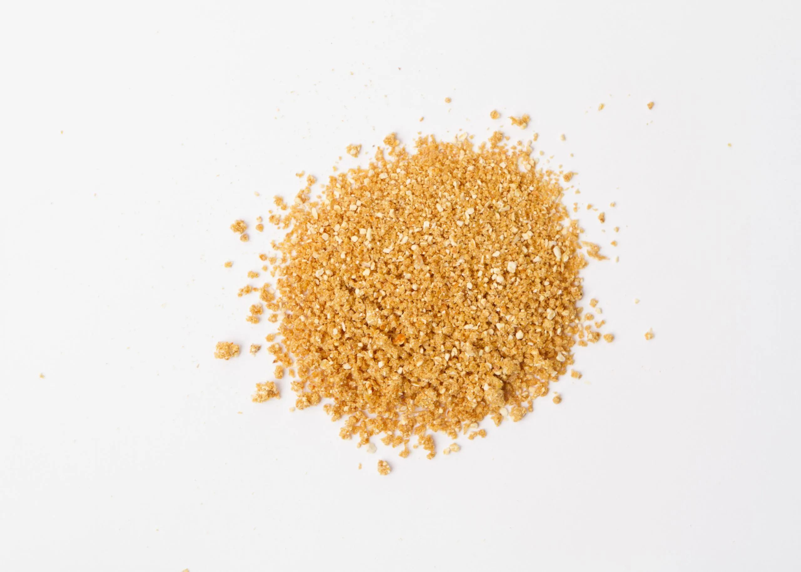 Traina® Natural Dried Orange, granules - small pile of dehydrated fruit on white background
