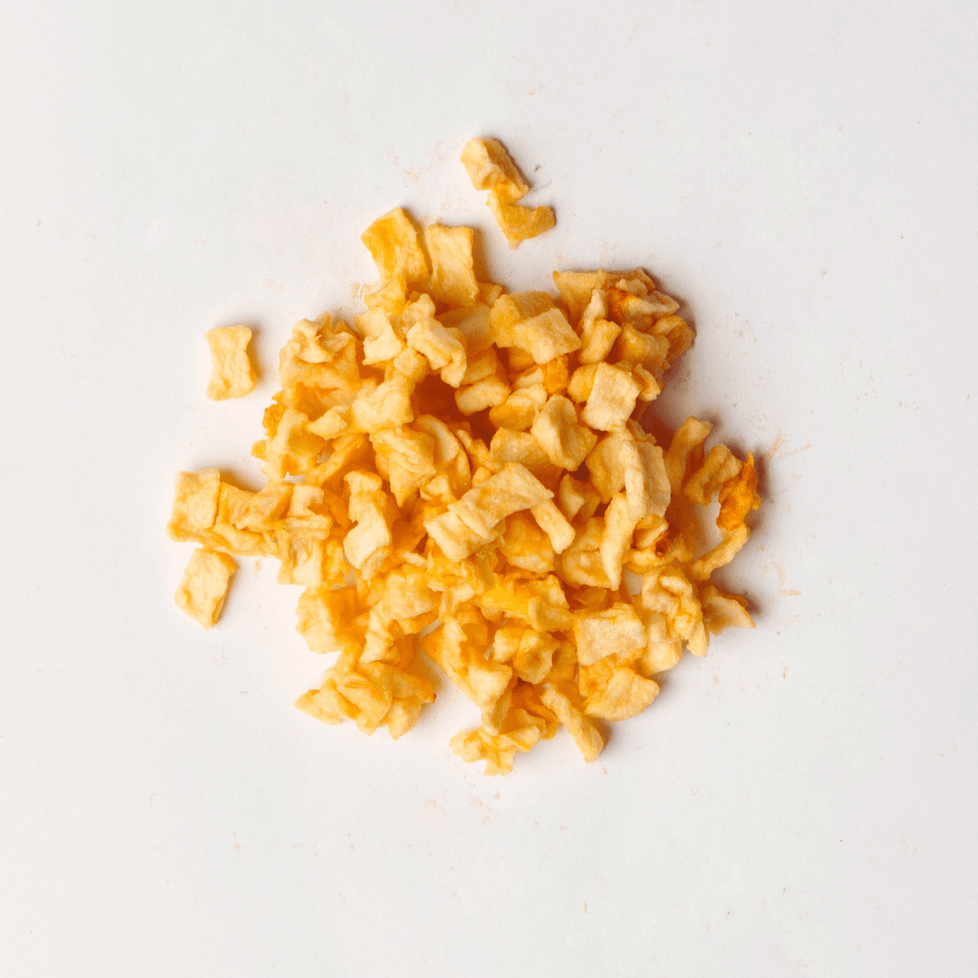 Traina® Natural Dried Apples, diced- small pile of sun dried fruit on white background.