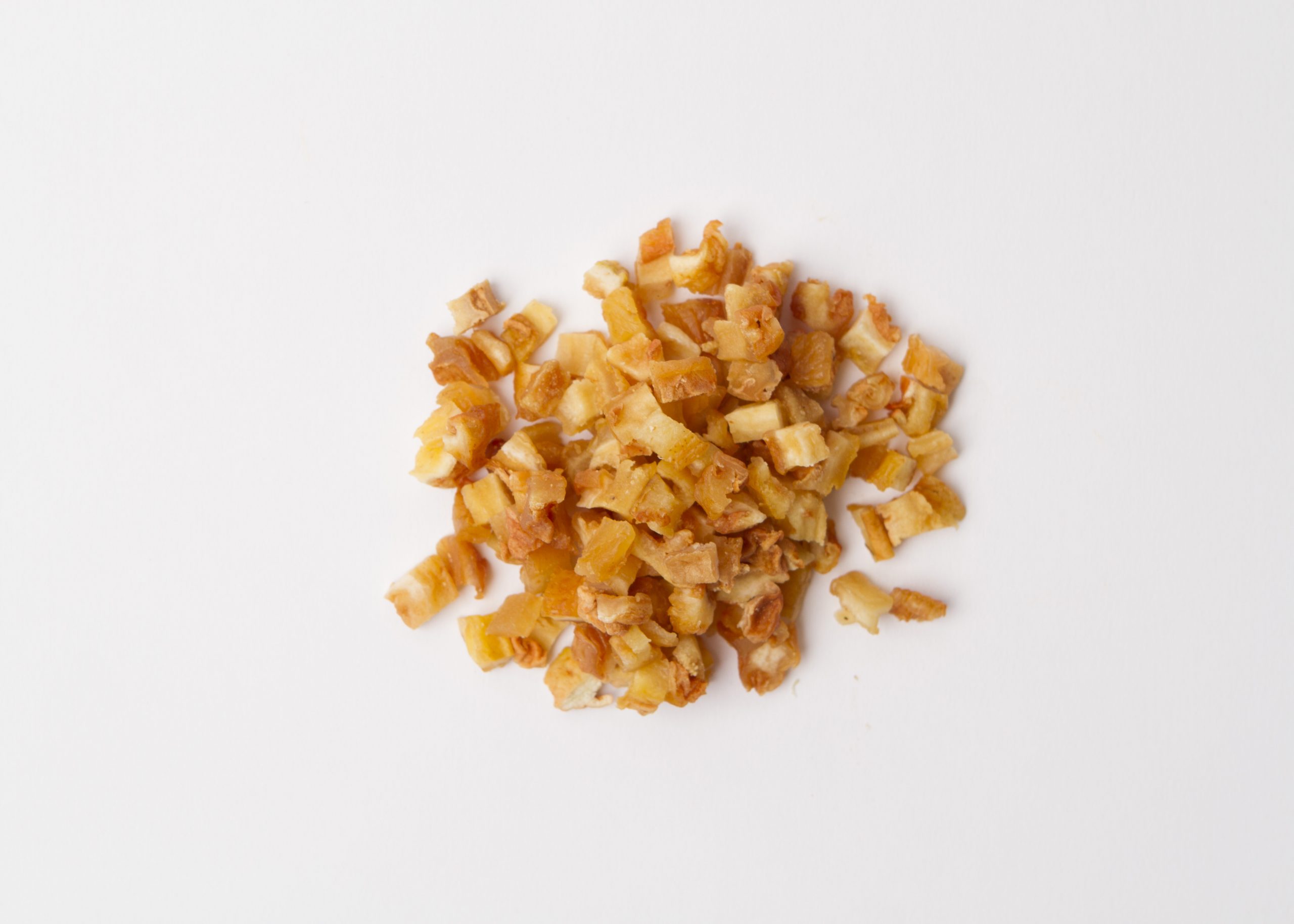 Traina® Dried Pears, diced - small pile of sun dried fruit on white background.