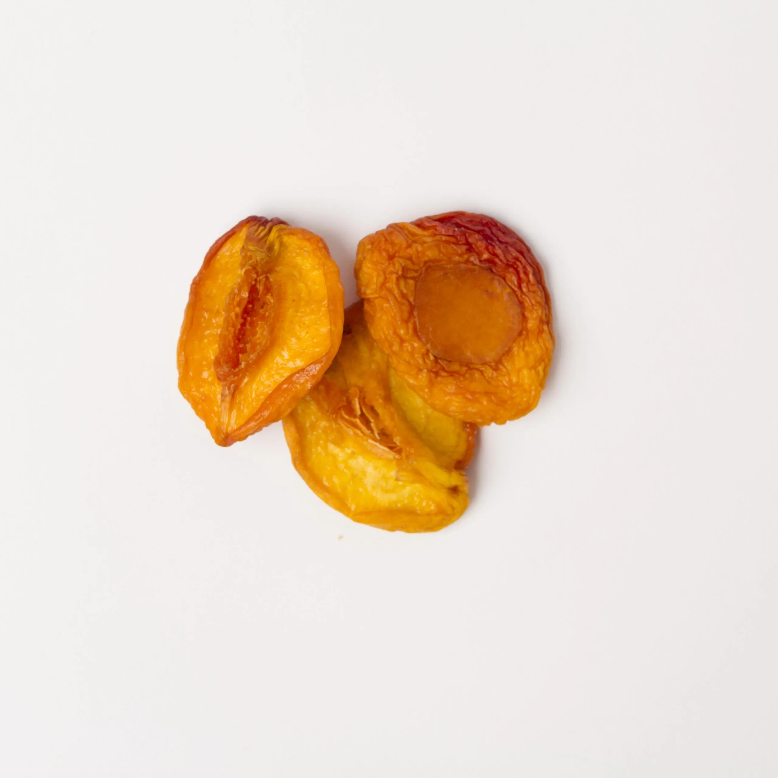 Traina® California Sun Dried Nectarines, Fancy, halves - small pile of sun dried fruit on white background.
