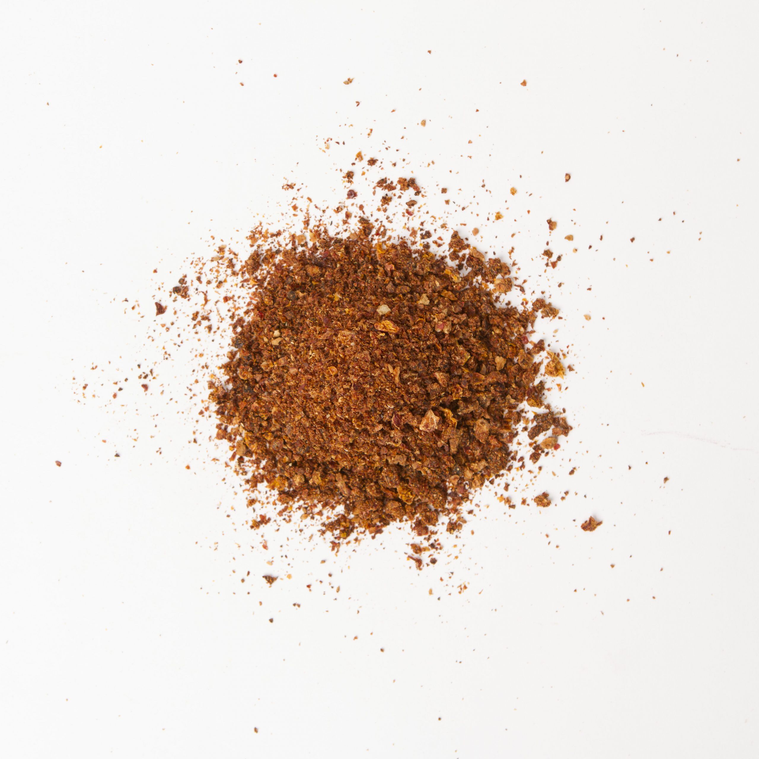 Traina® Natural California Sun Dried Tomatoes, with salt, triple-diced- small pile of sun dried tomatoes on white background.