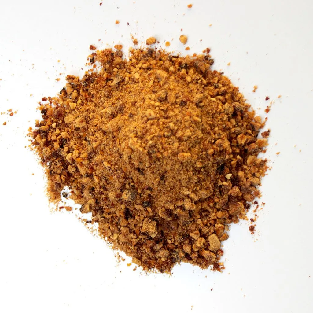 Traina® Natural California Sun Dried Peaches, granules - small pile of sun dried fruit on white background.