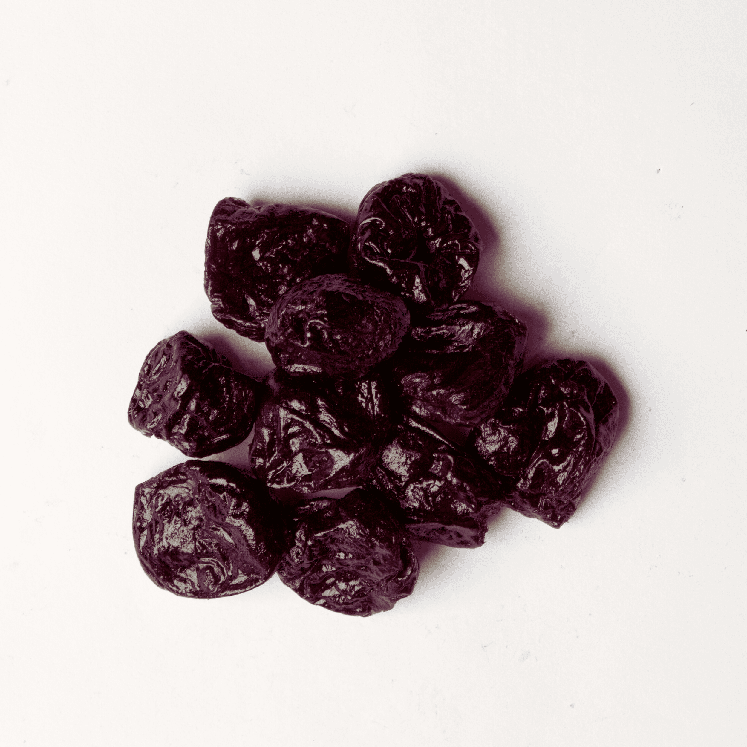 Traina® Dried Fruit Dried Prunes, Pitted, whole - small pile of dried fruit on white background.
