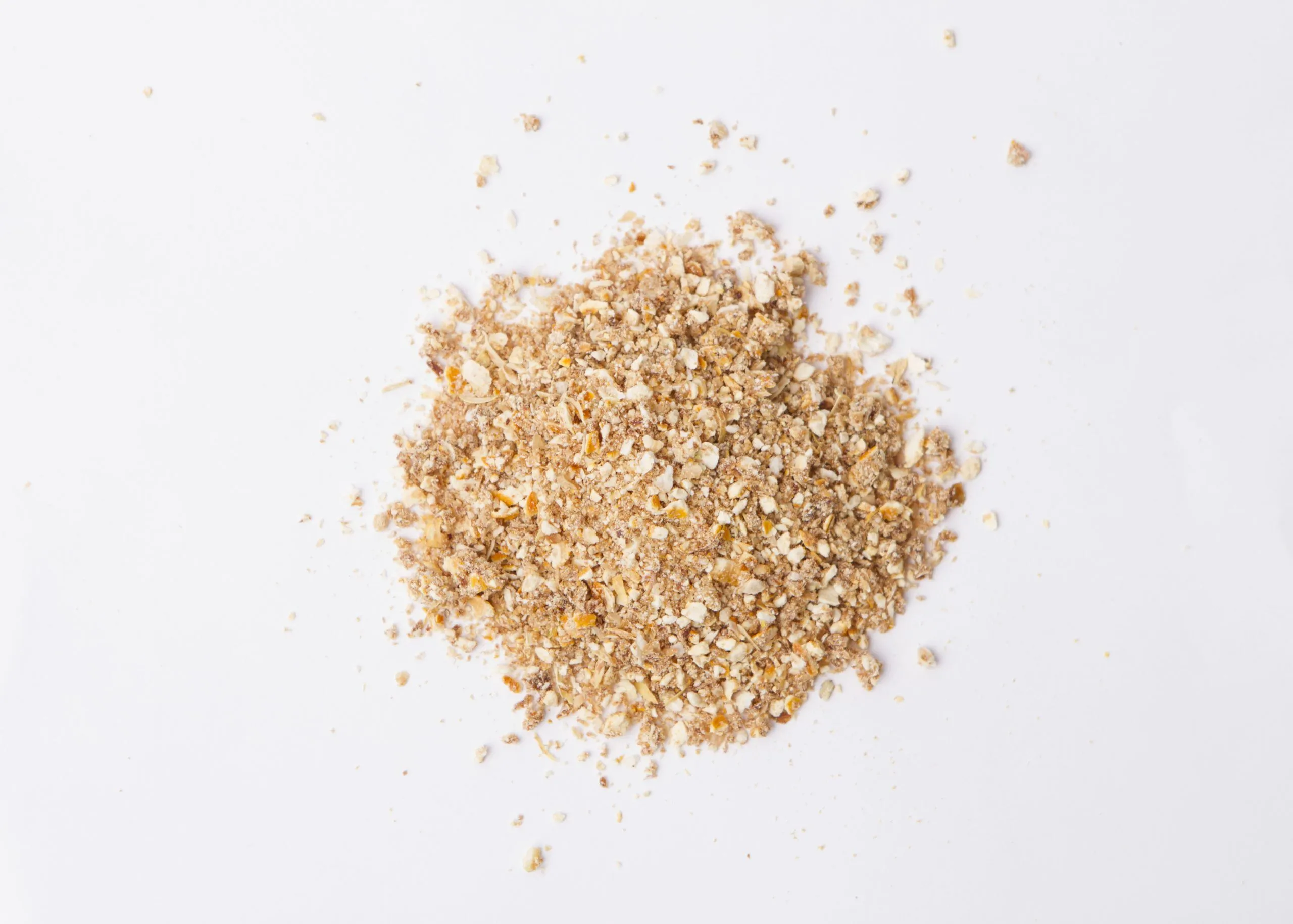 Traina® Natural Dried Lemon, granules - small pile of dehydrated fruit on white background