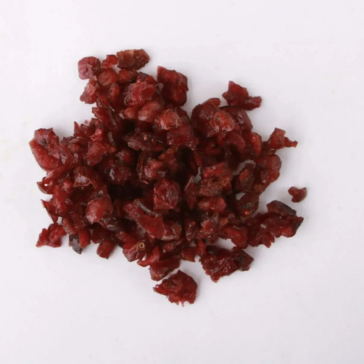 Traina® Dried Cranberries, Sweetened diced - small pile of dried dried fruit on white background