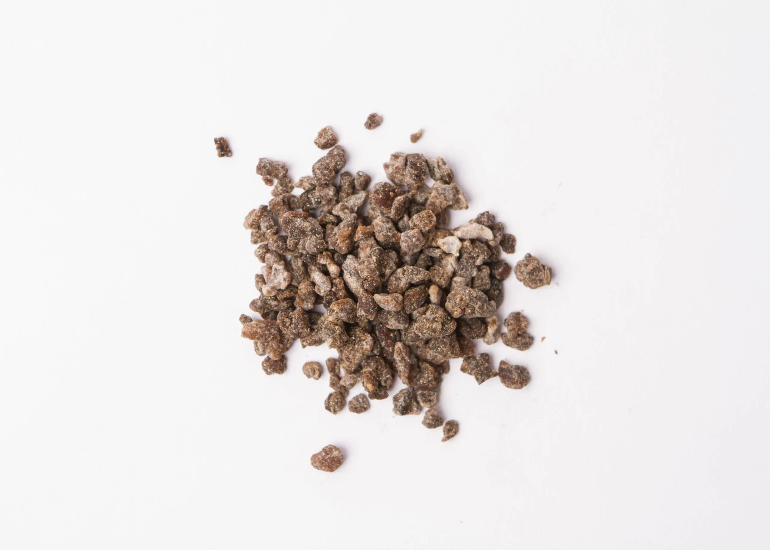 Traina® Natural Dried Banana, Crumbles. Small pile of dried fruit on white background.