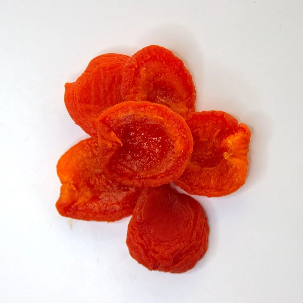 Traina® California Sun Dried Ruby Royal Apricots, Fancy, halves - small pile of sun dried fruit on white background