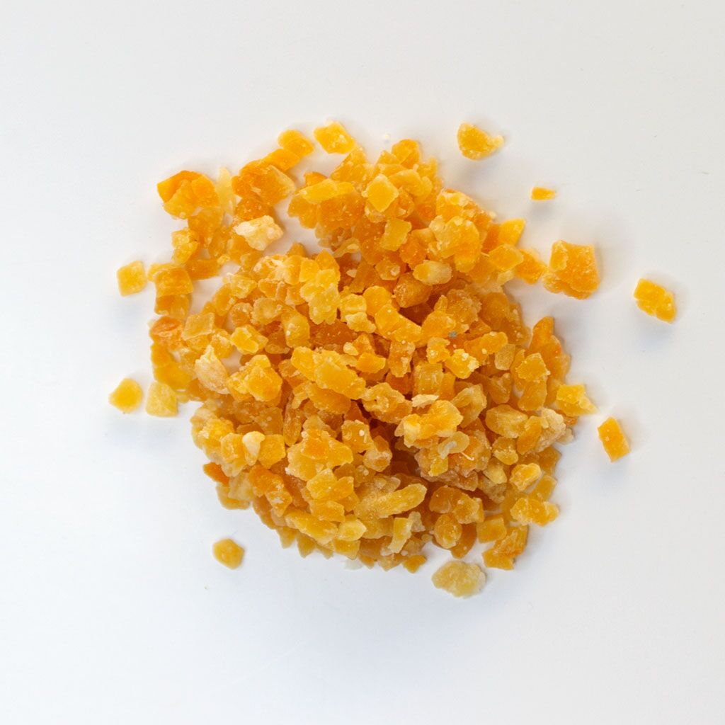 Traina® Dried Mango, Sweetened, Diced 3-5 mm - small pile of dried fruit on white background.