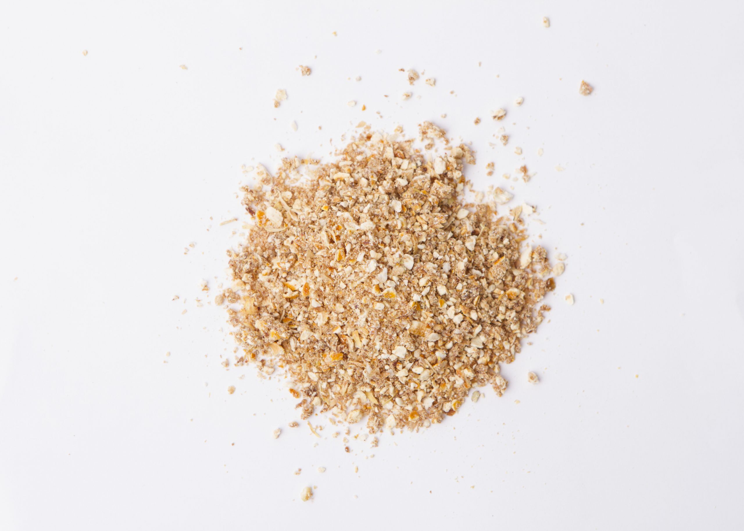 Traina® Natural Dried Lemon, granules - small pile of dehydrated fruit on white background