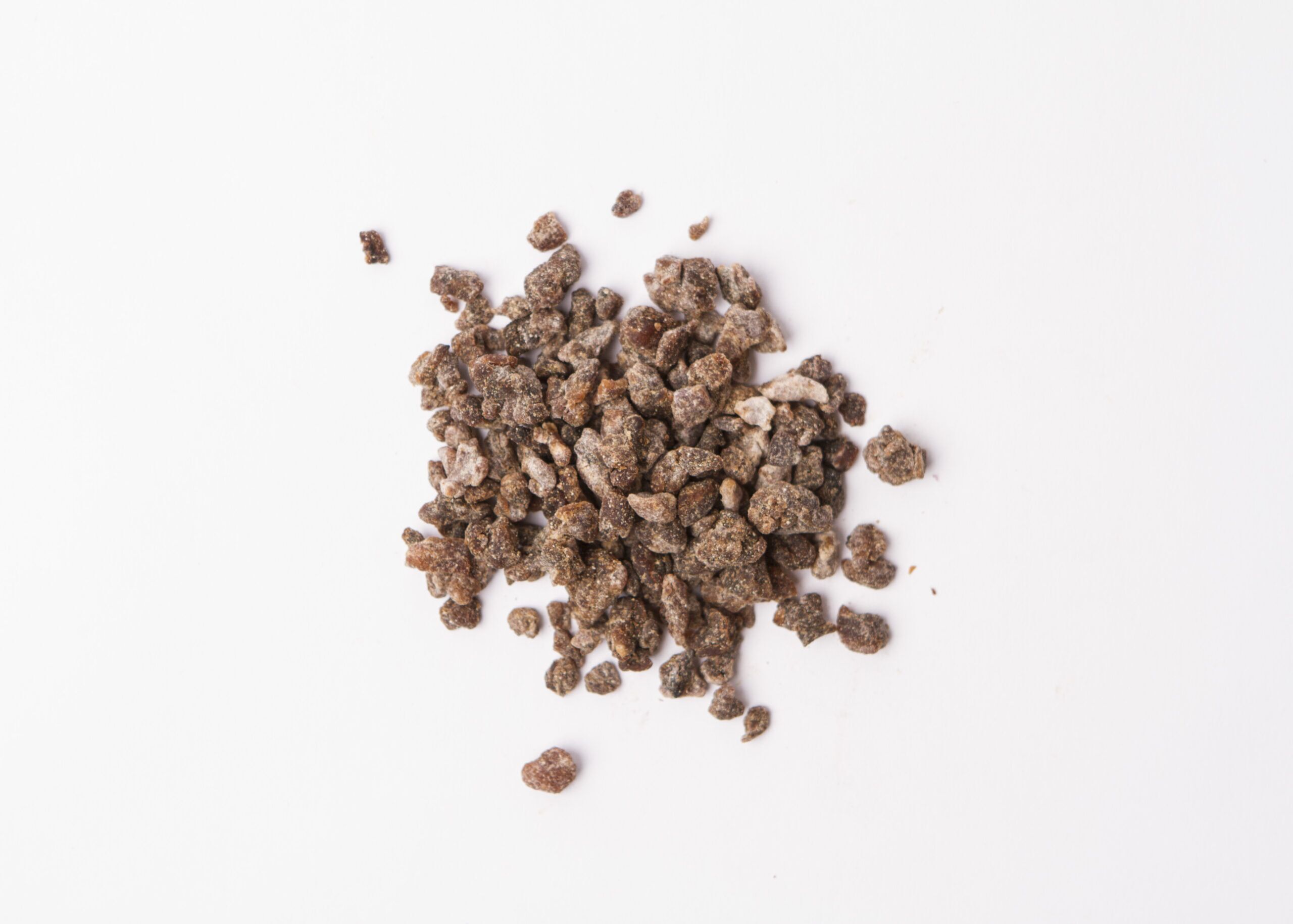 Traina® Natural Dried Banana, Crumbles. Small pile of dried fruit on white background.