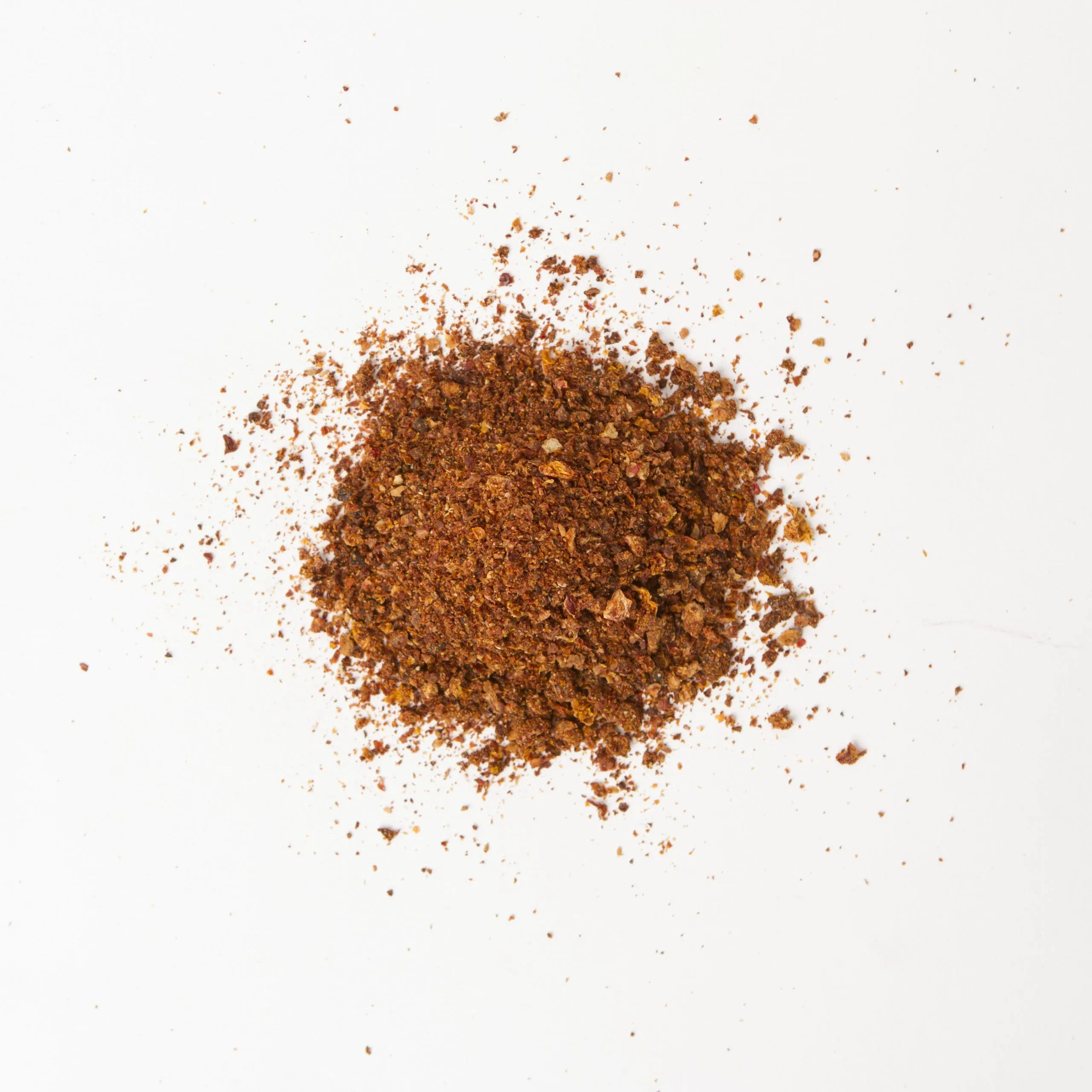 Traina® Natural California Sun Dried Tomatoes, with salt, triple-diced- small pile of sun dried tomatoes on white background.