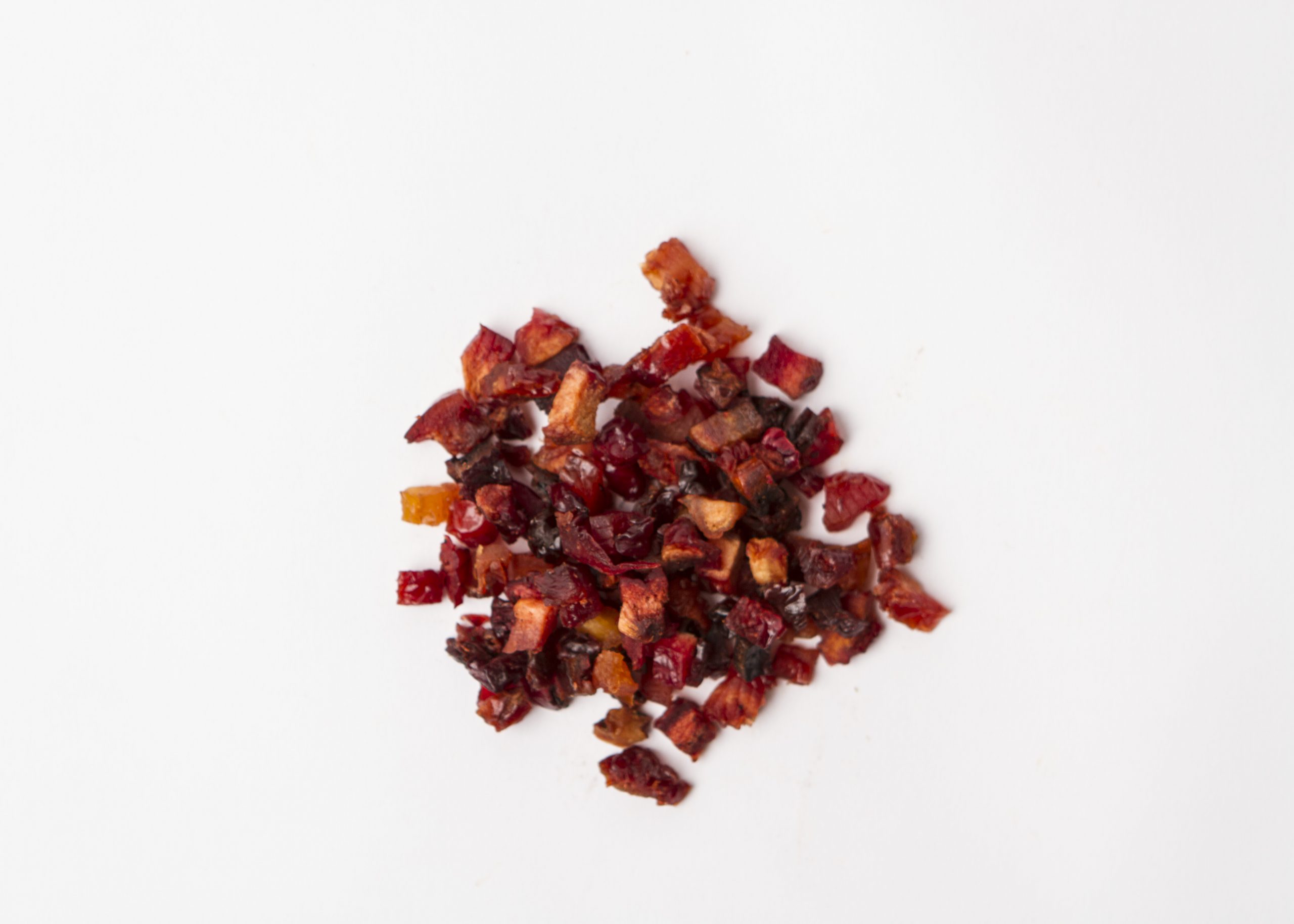 Traina® California Sun Dried Angelino Plums, diced - small pile of sun dried fruit on white background.