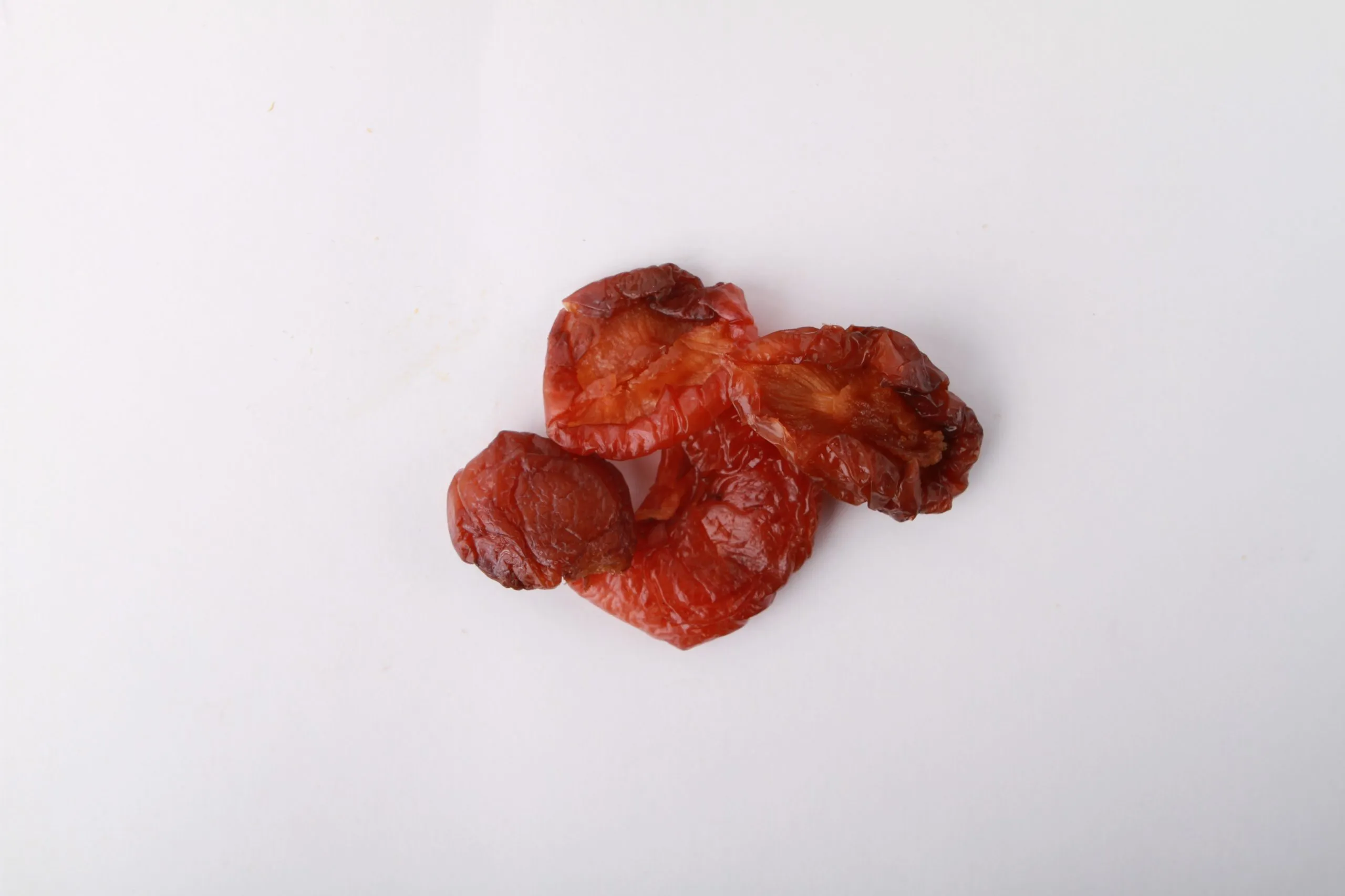 Traina® California Sun Dried Angelino Plums, Jumbo, halves - small pile of sun dried fruit on white background.