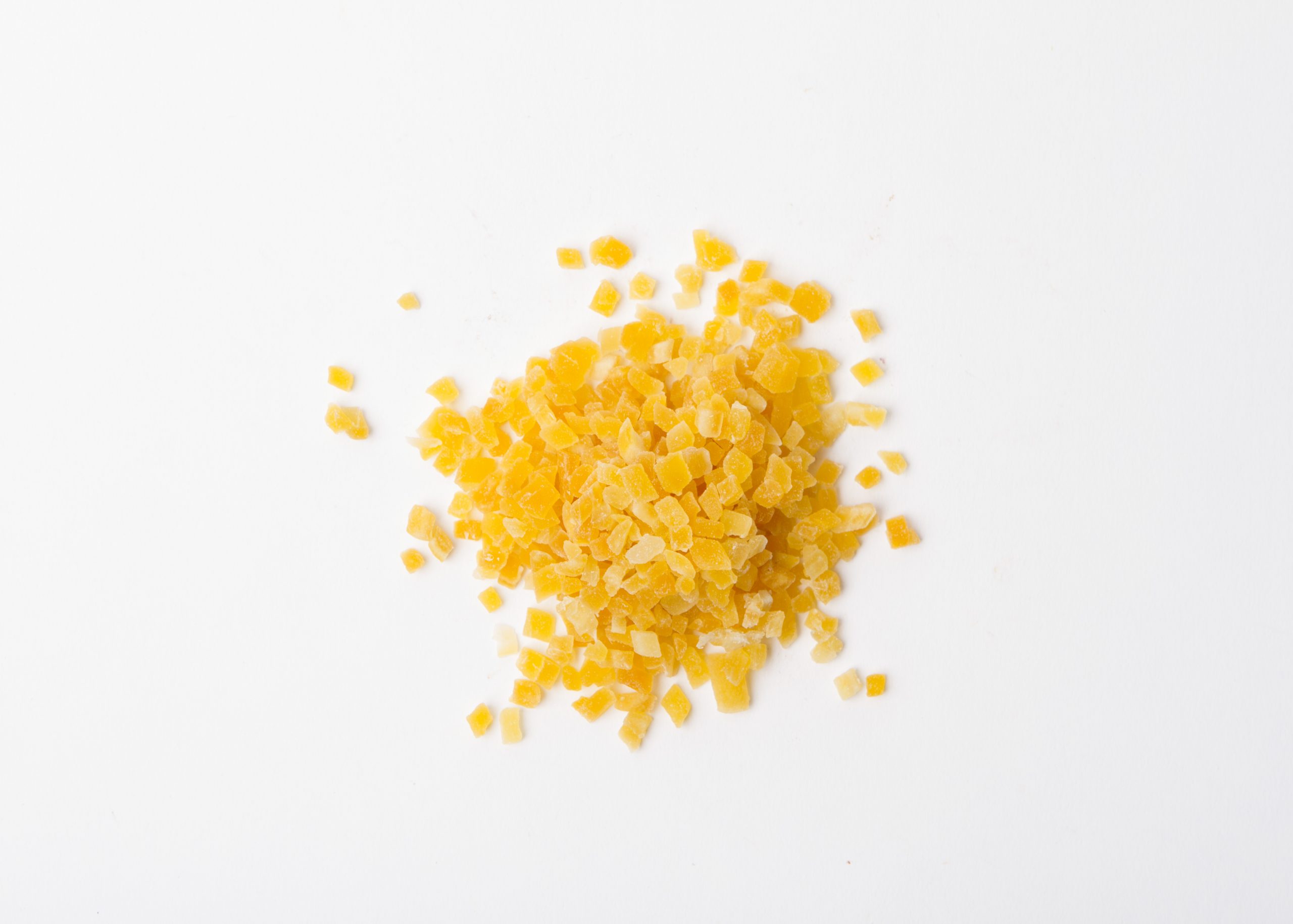 Traina® Dried Mango, Sweetened, diced 3-5 mm. Small pile of dried fruit on white background.