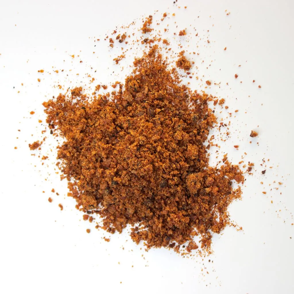 Traina® California Sun Dried Apricots, granules - small pile of sun dried fruit on white background.