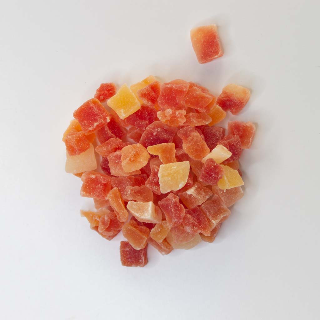 Traina® Dried Papaya, Sweetened, -diced 8-10mm. Small pile of dried fruit on white background.