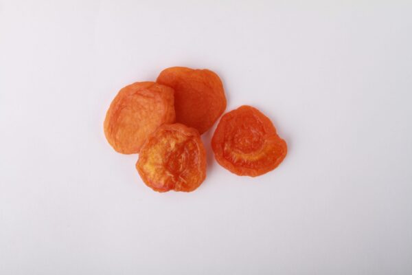 Traina® California Sun Dried Apricots, Jumbo, halves - small pile of sun dried fruit on white background.