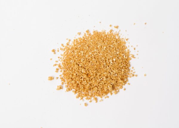 Traina® Natural Dried Orange, granules - small pile of dehydrated fruit on white background