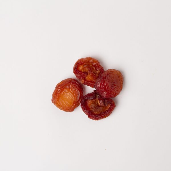 Traina® California Sun Dried Angelino Plums, Fancy, halves - small pile of sun dried fruit on white background.