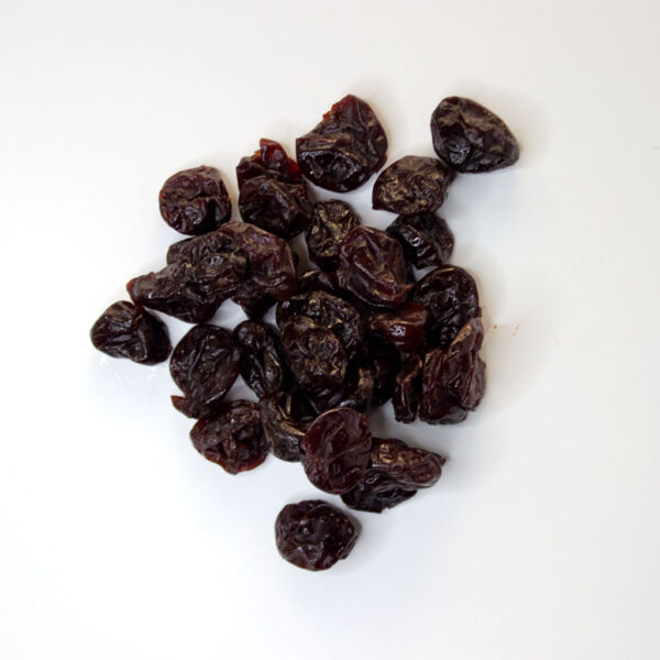 Traina® Dried Tart Cherries, sweetened, whole - small pile of sun dried fruit on white background.
