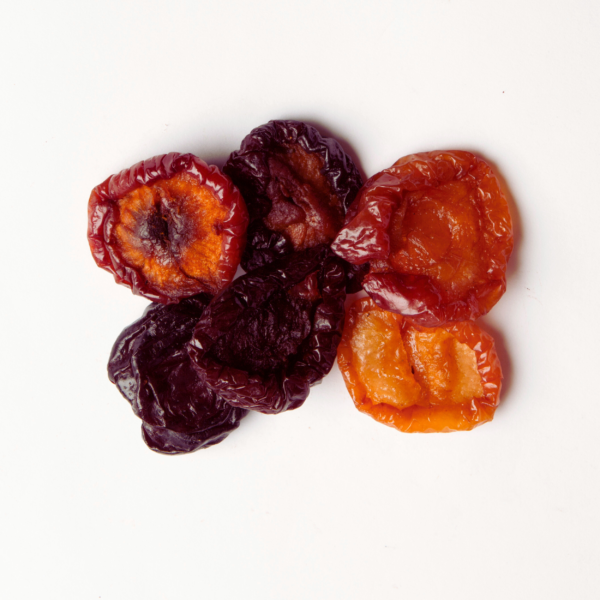 Traina® California Sun Dried Angelino Plums, Varigrade, halves - small pile of sun dried fruit on white background.
