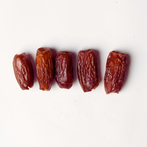 Traina® Deglet Noor Dates, pitted whole - small pile of dried fruit on white background.