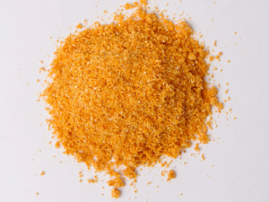 Traina® Organic Dried Orange, powder - small pile of dehydrated fruit on white background