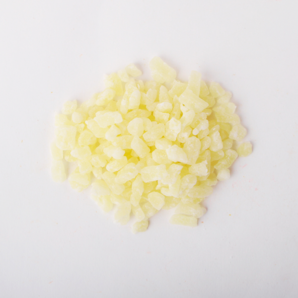 Traina® Dried Pineapple, Sweetened diced 5-7 mm - small pile of dried fruit on white background.