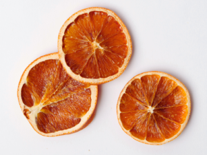 Traina® Organic Dried Orange, slices - three pieces of dried fruit on white background