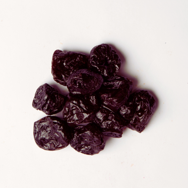 Traina® Dried Fruit Dried Prunes, Pitted, whole - small pile of dried fruit on white background.